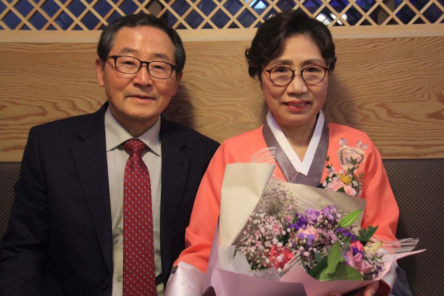 한복을 입고 꽃다발을 든 장정숙 님과 정장 차림의 남편
